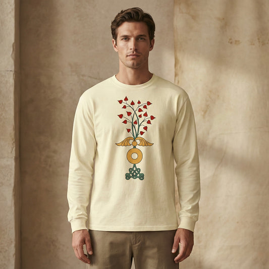 Man wearing a butter long-sleeve shirt with a decorative design against a textured beige wall.